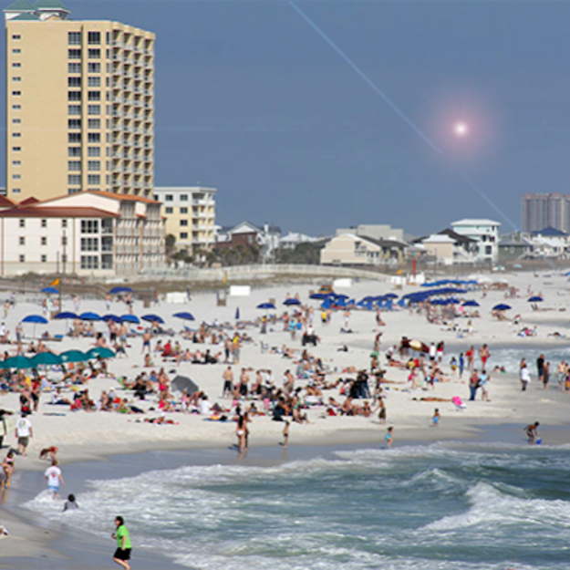 Many people sunbathing on a city beach